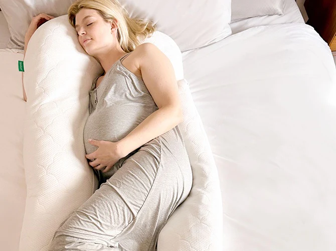 pregnant person sleeping in a C-shape pillow