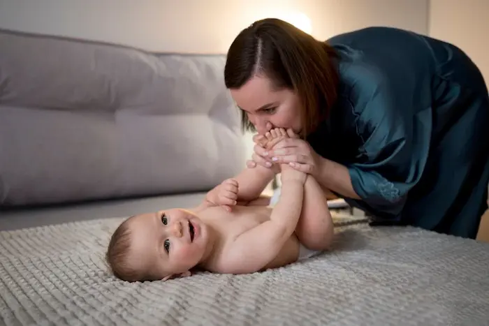 A calm, comforting photo of a parent holding a baby close, cheek-to-cheek, with a warm washcloth visible in the parent’s hand near the baby’s ear