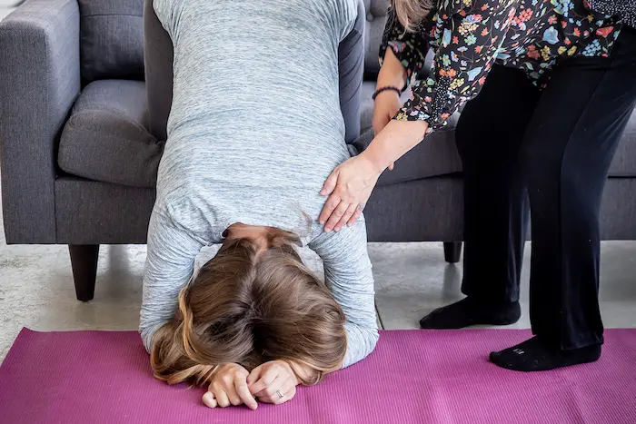 A calm, supportive image of a partner helping a pregnant person into a gentle