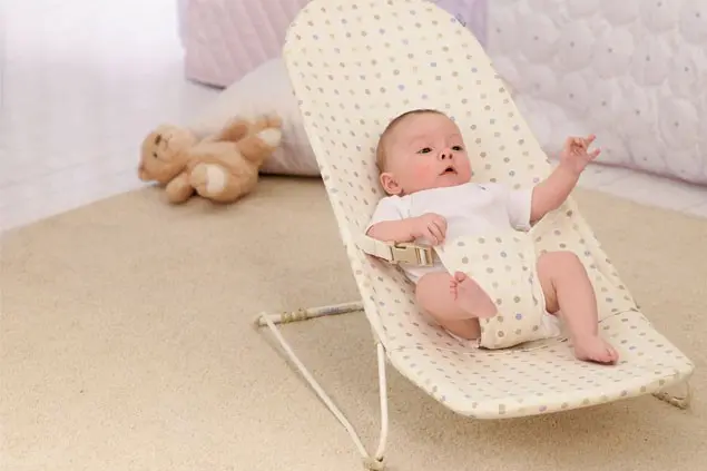 A close-up of a bouncer seat showing the spring mechanism that allows the bouncing motion