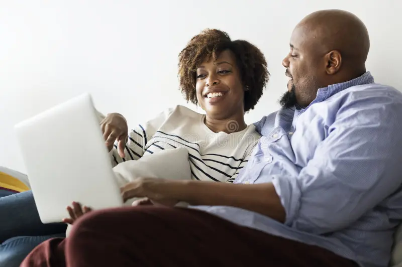 A couple relaxing together on the couch after baby is asleep