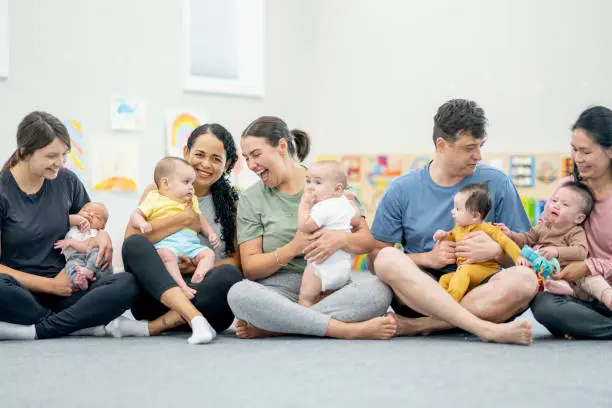 A group of diverse mothers sitting in a circle at a parenting class or support group
