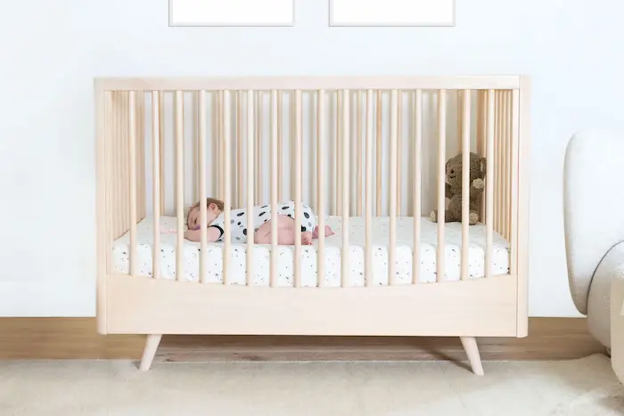 A minimalist crib with a tight-fitting sheet