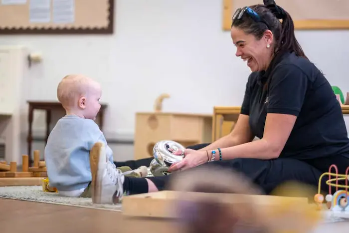 A mother embracing her baby at daycare pickup, both smiling