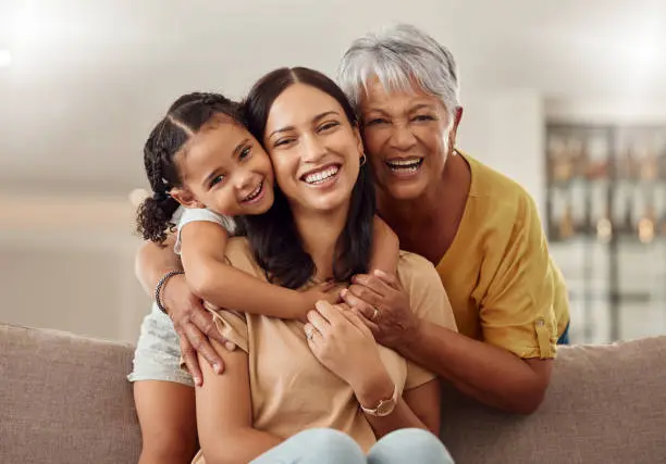 A multi-generational photo of a grandmother, mother, and baby together,
