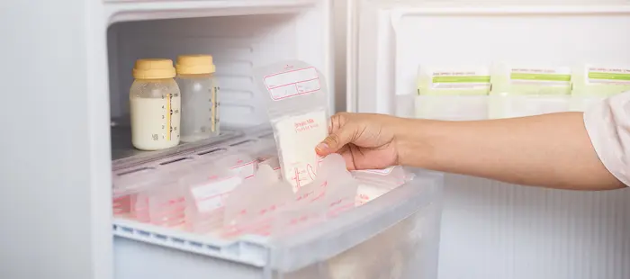 A refrigerator and freezer with breast milk storage containers clearly labeled and organized by date