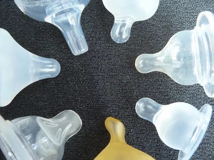 Comparison of baby bottle nipples showing various shapes, flow rates, and materials