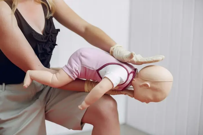 Demonstration of back blows and chest thrusts on an infant