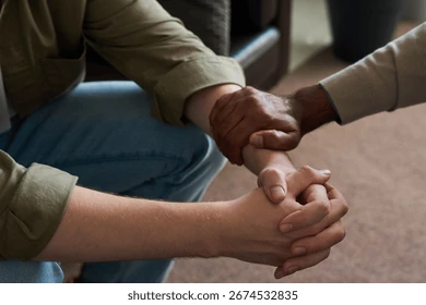 Two pairs of hands gently cradling a smallly